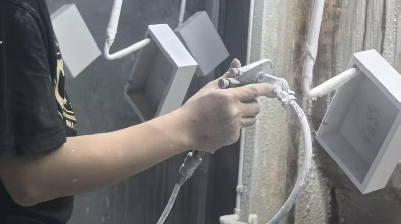 Worker respraying wooden box